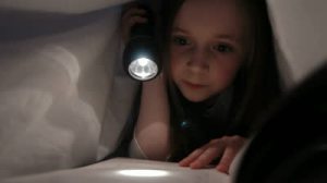 stock-footage-child-reading-in-bed-little-girl-reading-by-torch-light-under-the-bed-sheets